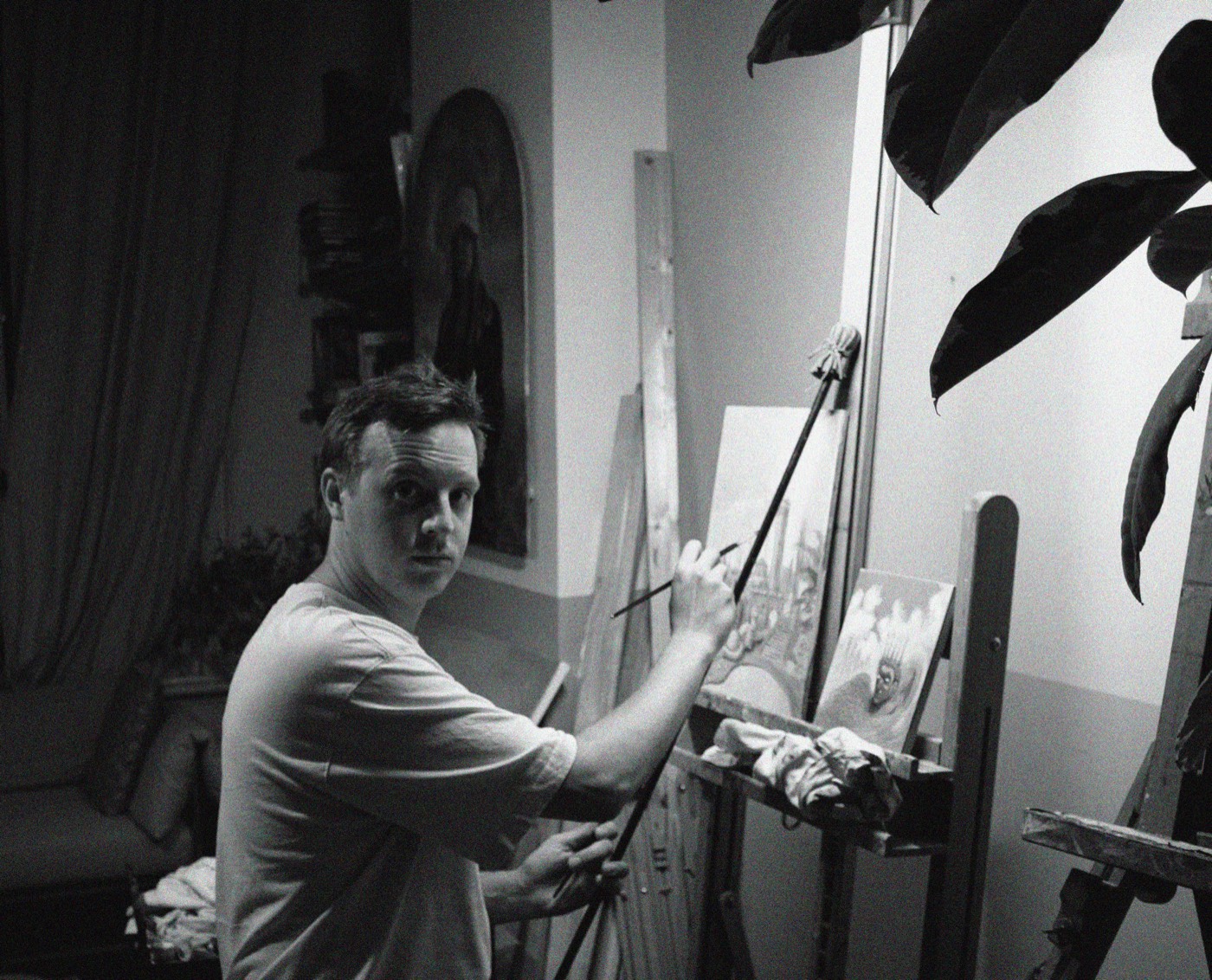 Jelle van de Ridder at work in his studio, mahlstick and brush in hand at the easel.